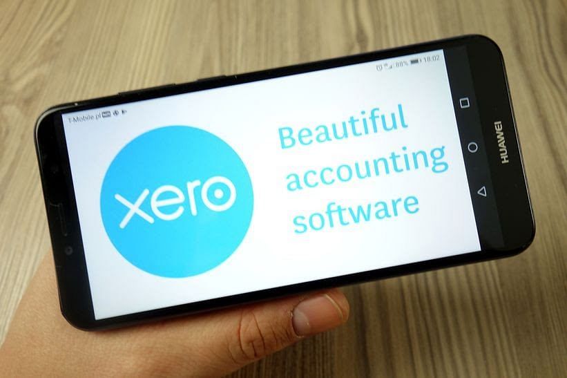 shot of a hand holding a phone with its screen showing the xero small business software