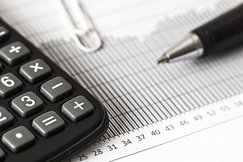 closeup shot of a calculator, a pen, and a graph symbolizing accounting