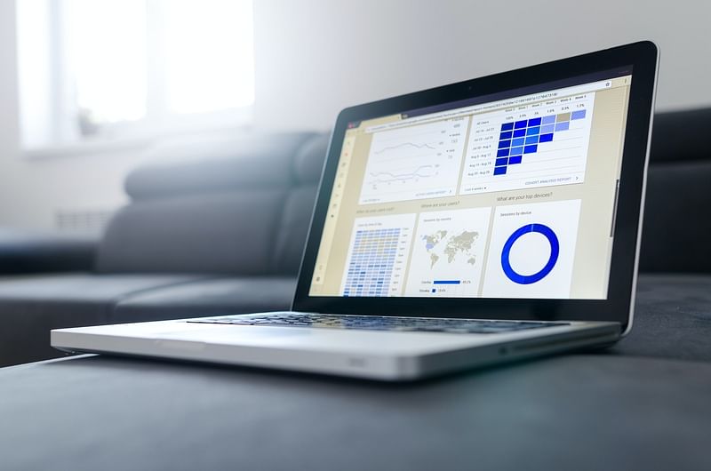 a laptop showing a dashboard that has charts and the world map